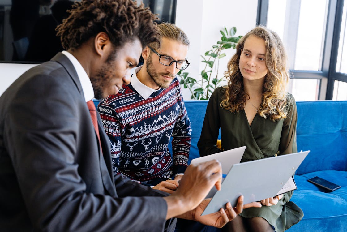 Free A diverse group of young professionals engaged in a business meeting inside a modern office. Stock Photo